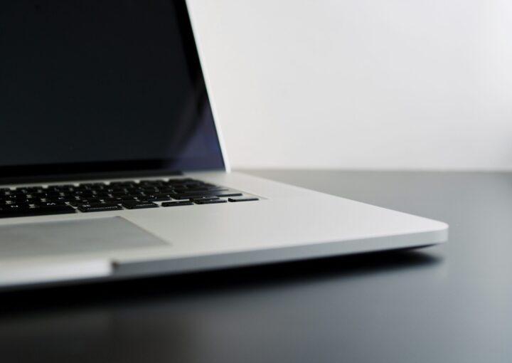 silver laptop computer on black table